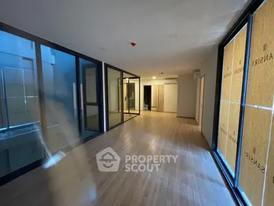 Spacious modern interior with large windows and wooden flooring, ideal for versatile living space.