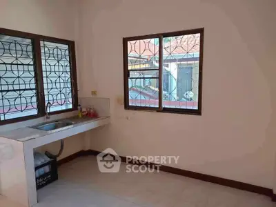 Spacious kitchen area with large windows and natural light.