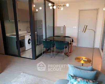 Modern open-plan living room with dining area and glass partitioned kitchen
