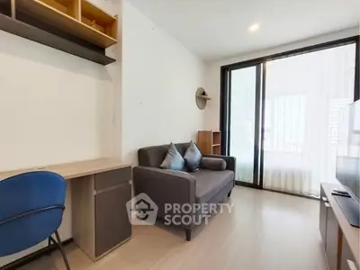 Modern living room with cozy sofa, study desk, and large window for natural light.