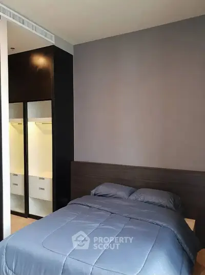 Modern bedroom with sleek design and cozy bedding in a stylish apartment.