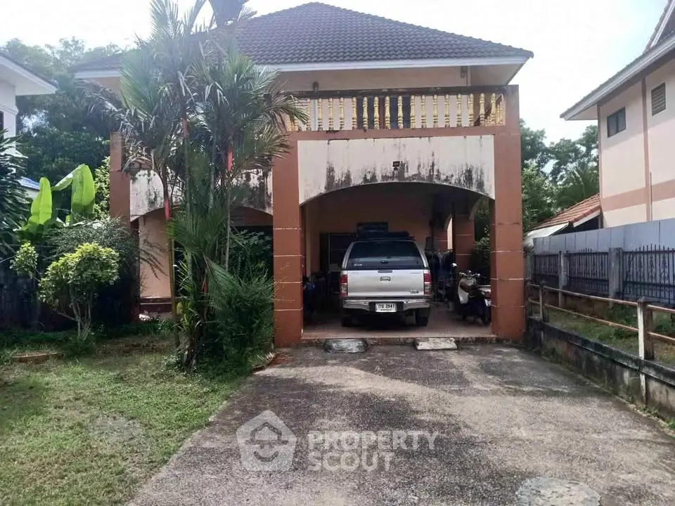 Charming two-story house with driveway and lush greenery, perfect for family living.