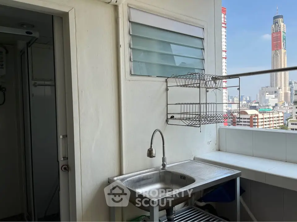 Charming balcony with city view and stainless steel sink, perfect for urban living.