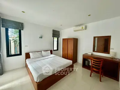Spacious bedroom with modern furnishings and natural light in a serene setting.