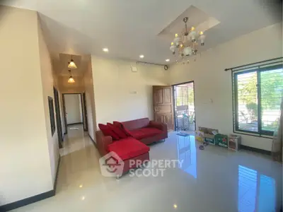 Spacious living room with modern chandelier and red sofa in bright home