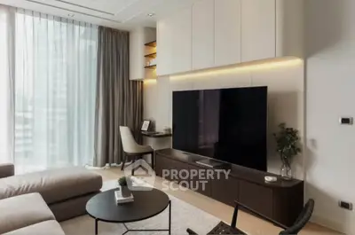 Modern living room with large TV, stylish furniture, and floor-to-ceiling windows.