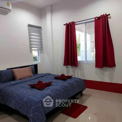 Cozy bedroom with modern decor and natural light, featuring stylish bedding and vibrant curtains.