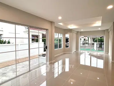 Spacious modern living room with large windows and glossy tile flooring