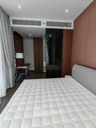 Modern bedroom with sleek design, featuring a large bed, stylish wardrobe, and elegant lighting.
