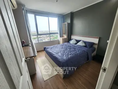 Cozy bedroom with city view, featuring a comfortable bed and modern decor, perfect for relaxation.
