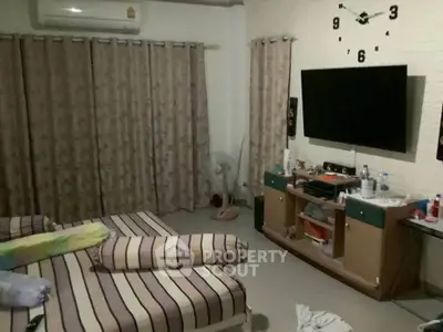 Cozy bedroom with twin beds, wall-mounted TV, and air conditioning