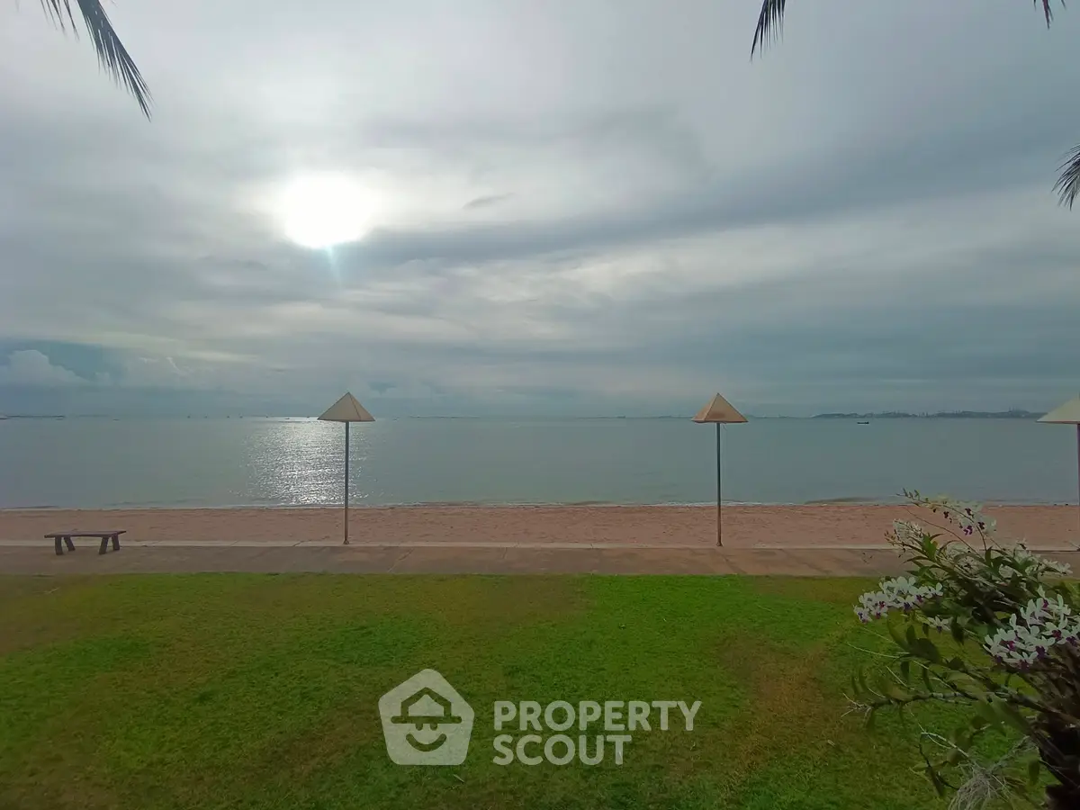 Stunning beachfront view with lush green lawn and serene ocean horizon.