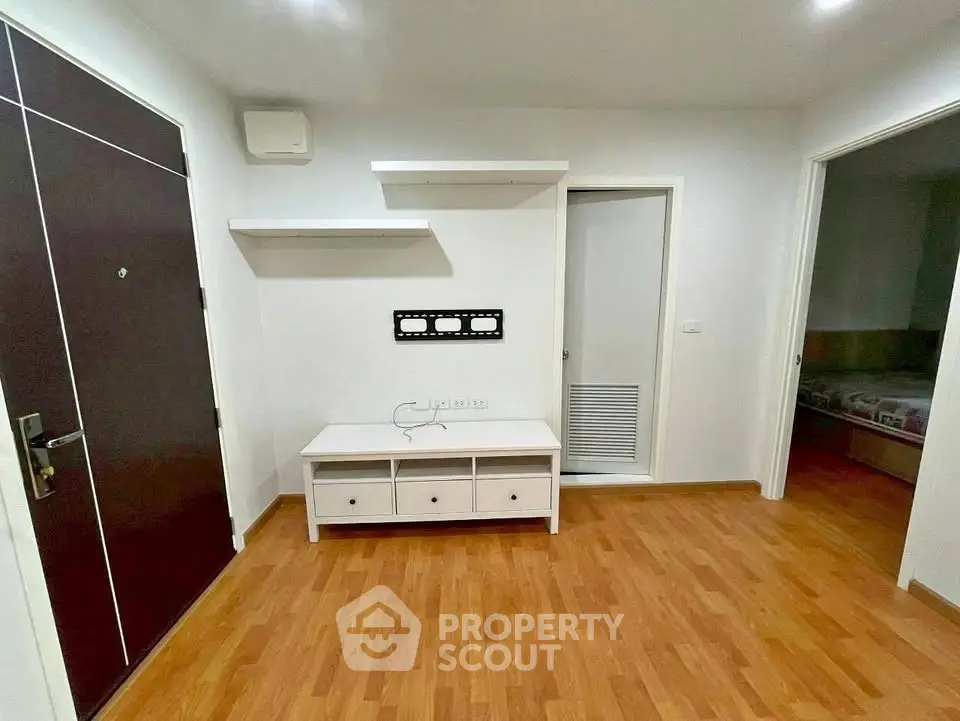 Modern apartment interior with wooden flooring and wall-mounted shelves, ideal for cozy living.