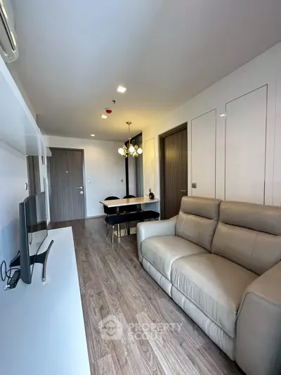 Modern living room with sleek furniture and wooden flooring in a stylish apartment.