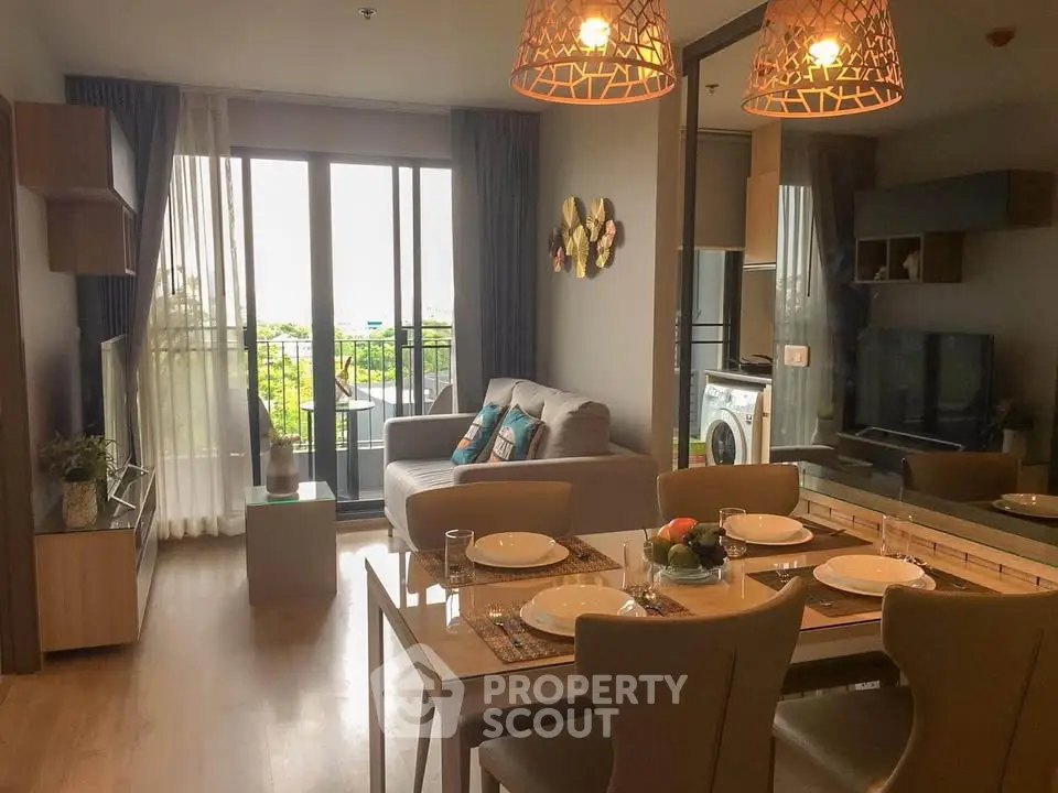 Modern living room with dining area and balcony view in a stylish apartment.