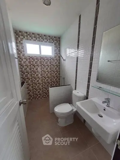 Modern bathroom with stylish tile design and natural light.