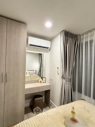 Cozy bedroom with modern decor and air conditioning, featuring a stylish vanity and elegant curtains.