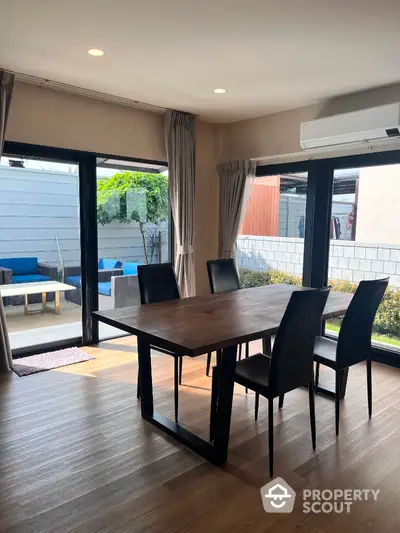 Modern dining area with wooden table and garden view in stylish home