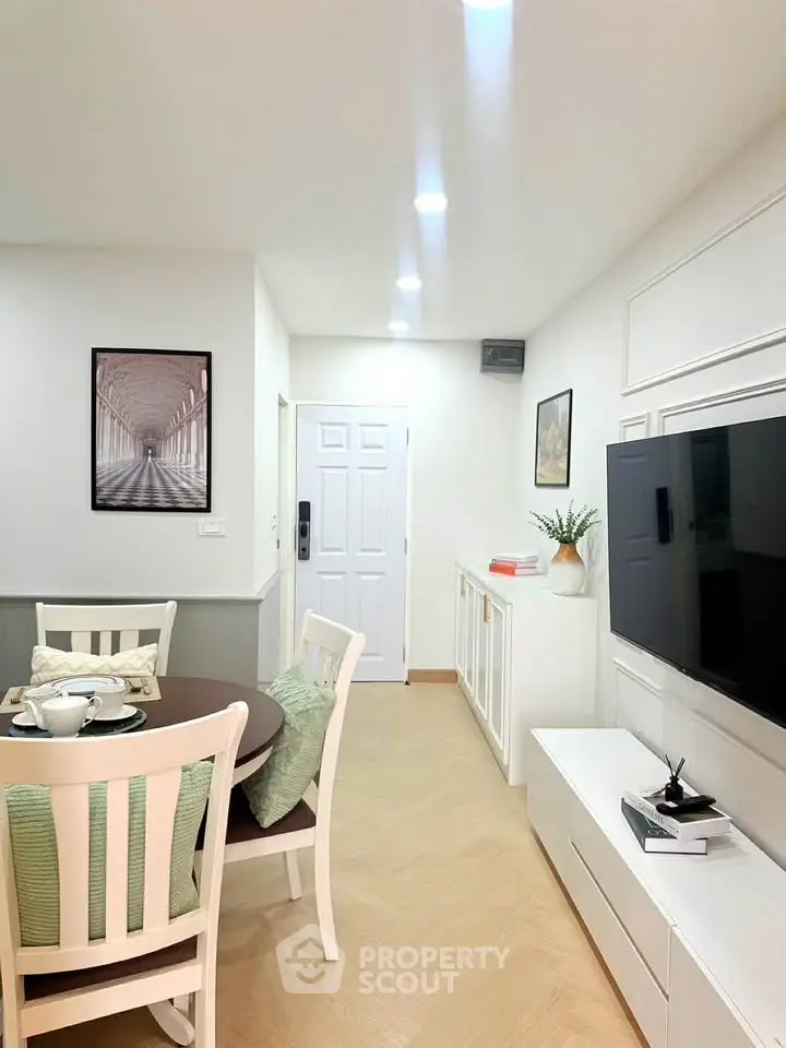 Modern living room with elegant dining area and wall-mounted TV, featuring stylish decor and cozy ambiance.