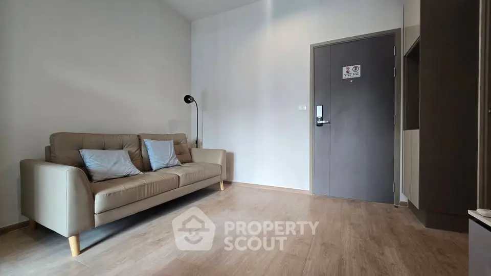 Modern living room with stylish sofa and floor lamp, featuring sleek wooden flooring and neutral tones.