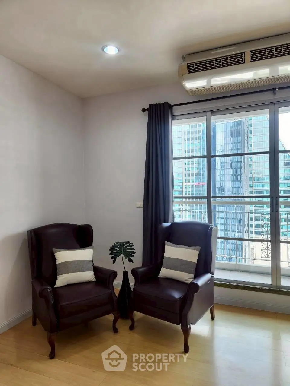 Modern living room with city view and elegant armchairs