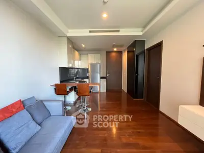 Modern open-plan living room with sleek kitchen and hardwood floors