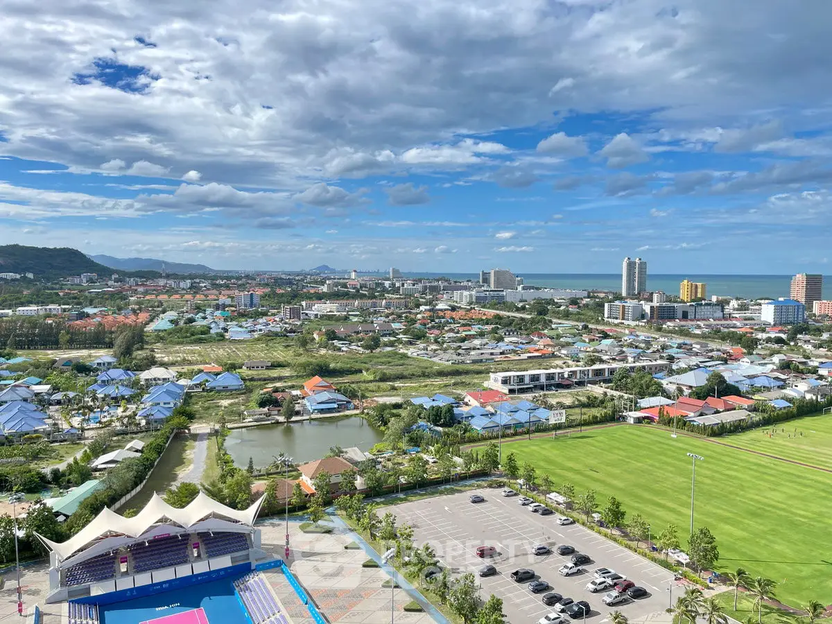 Stunning panoramic view of cityscape with lush greenery and ocean horizon, perfect for real estate investment.