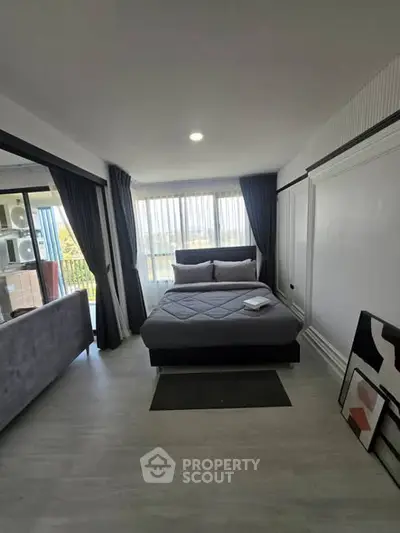 Modern bedroom with large windows and stylish decor, offering a cozy and inviting atmosphere.