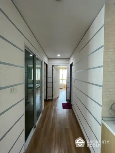 Modern hallway with wooden flooring and stylish wall design in a contemporary home.