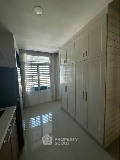 Spacious kitchen with sleek cabinetry and large window for natural light.