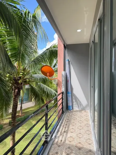 Charming balcony with lush garden view and modern railing, perfect for relaxation.