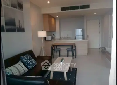 Modern open-plan living room and kitchen with stylish decor and cozy seating area.
