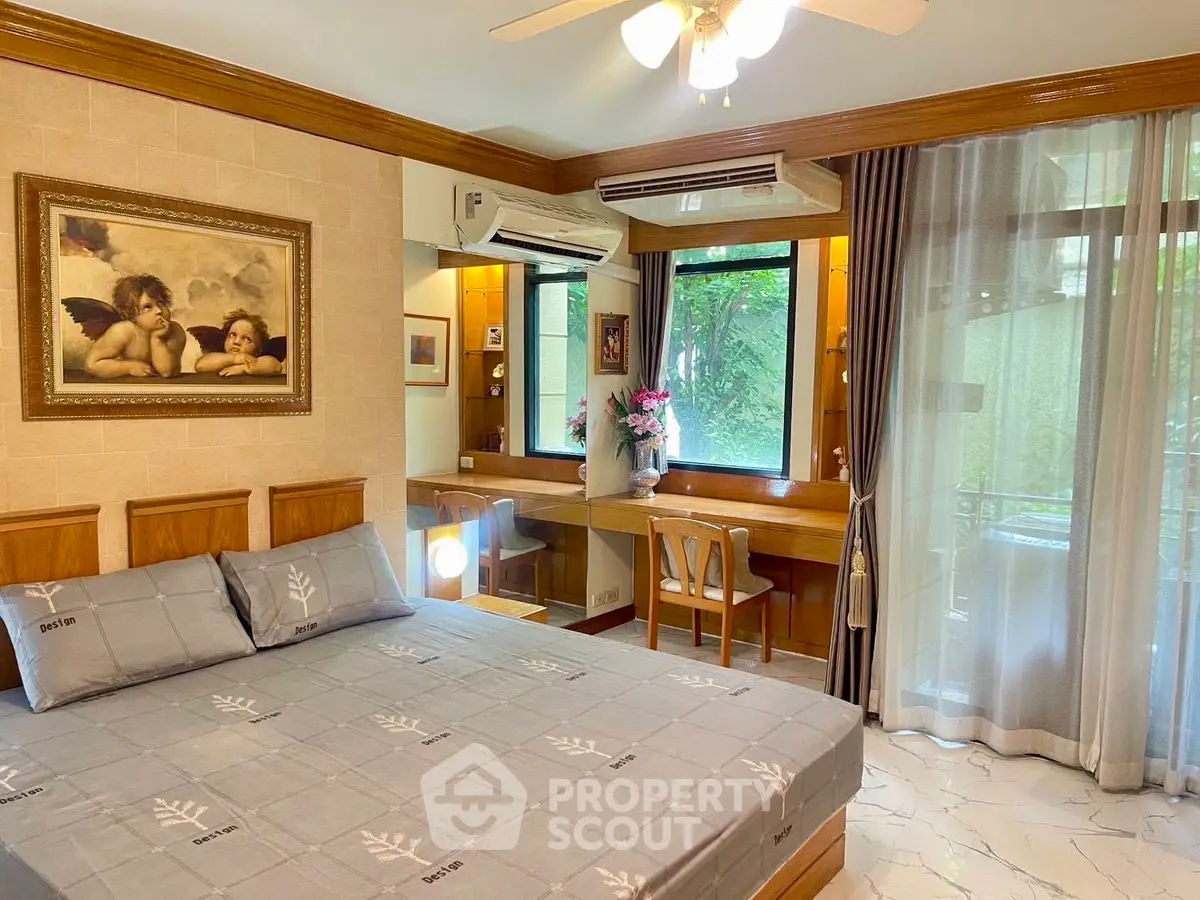 Charming bedroom with elegant decor, large windows, and a cozy workspace, perfect for relaxation and productivity.