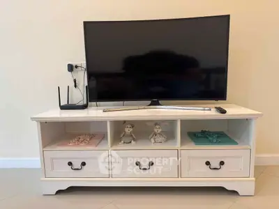 Charming living room setup with elegant TV stand and modern flat-screen TV, perfect for cozy home entertainment.