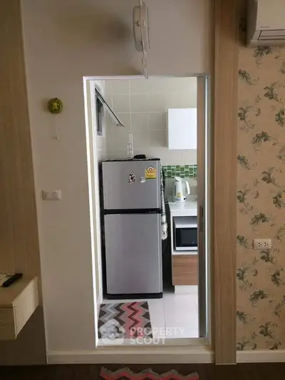 Compact kitchen with modern fridge and stylish backsplash in cozy apartment.
