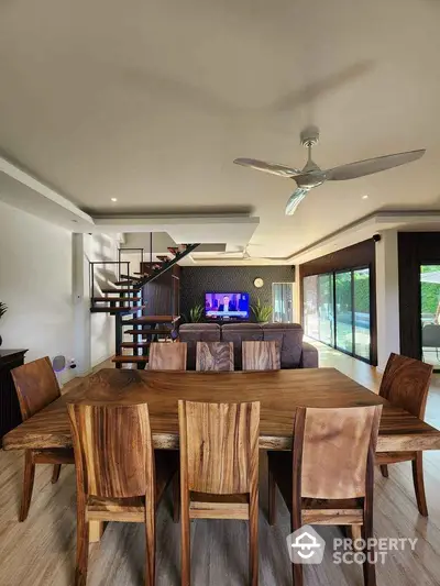 Spacious modern living room with wooden dining set and stylish staircase