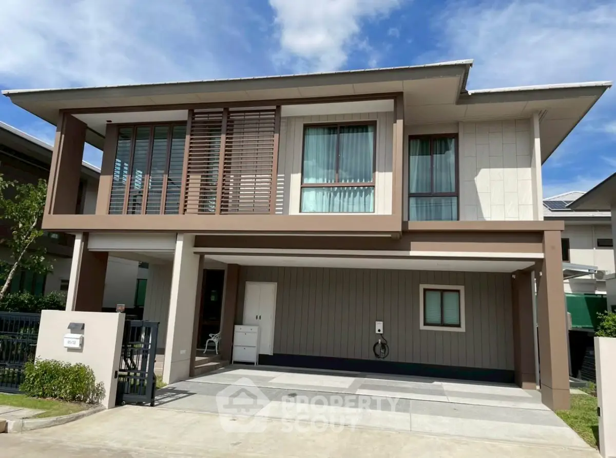 Modern two-story house with large windows and spacious driveway