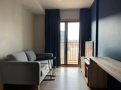 Modern living room with balcony view, featuring sleek furniture and natural light.