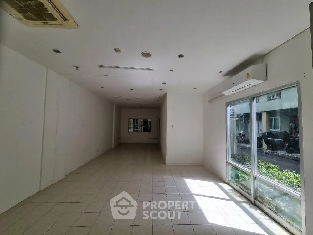 Spacious commercial space with large windows and tiled flooring, ideal for retail or office use.