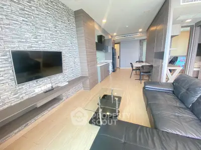Modern living room with stone accent wall and sleek black leather sofa