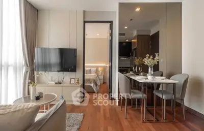 Modern living room with dining area and view into a cozy bedroom, featuring elegant decor and natural light.