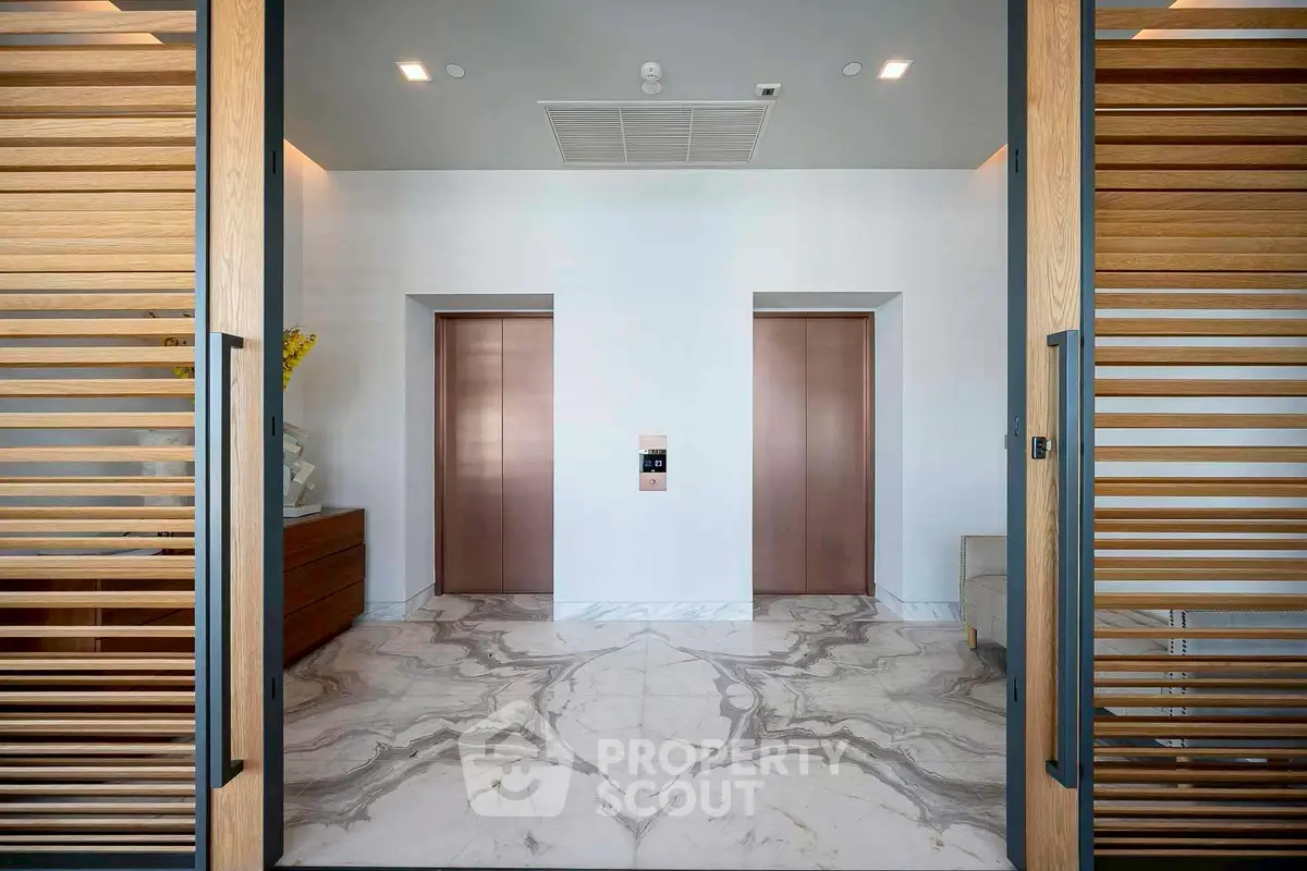 Luxurious modern elevator lobby with marble flooring and wooden accents