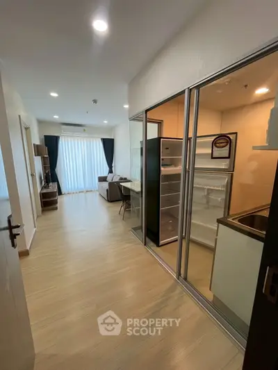 Modern apartment interior with open layout kitchen and spacious living area, featuring sleek appliances and natural light.