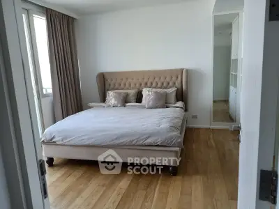 Spacious bedroom with elegant bed and wooden flooring in modern apartment
