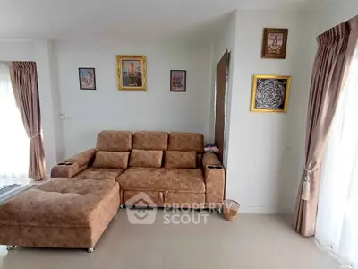 Spacious living room with elegant brown sofa and framed wall art, perfect for relaxation.