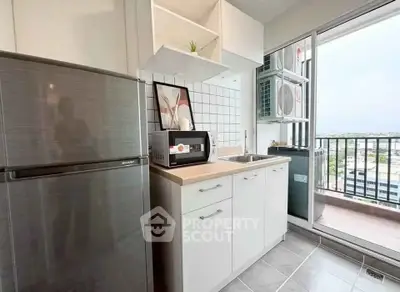 Modern kitchen with sleek appliances and balcony view in urban apartment