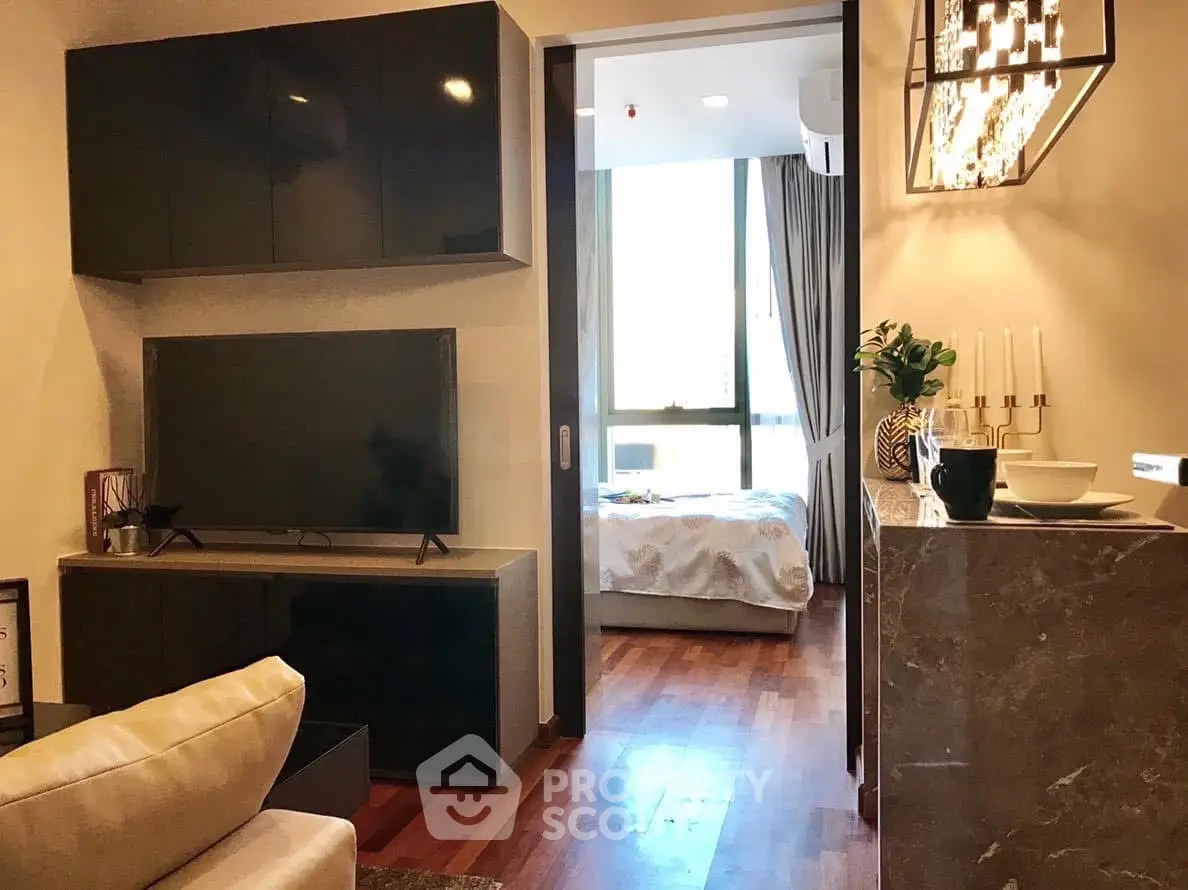 Modern living room with sleek TV setup and view into cozy bedroom