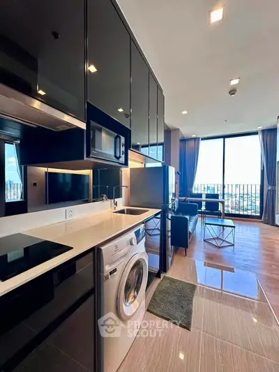Modern kitchen with sleek black cabinets and built-in appliances in a stylish apartment