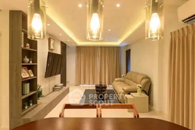 Spacious modern living room with elegant lighting and cozy seating area.