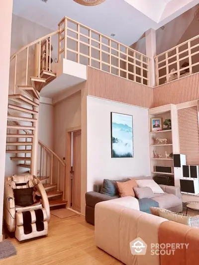 Spacious living room with modern loft design, featuring a spiral staircase and cozy seating area.